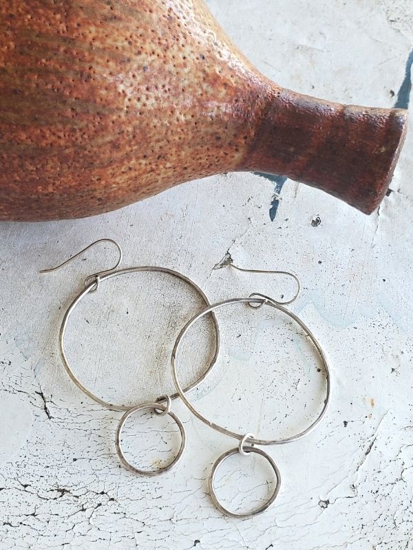 silver double hoop earrings on white table